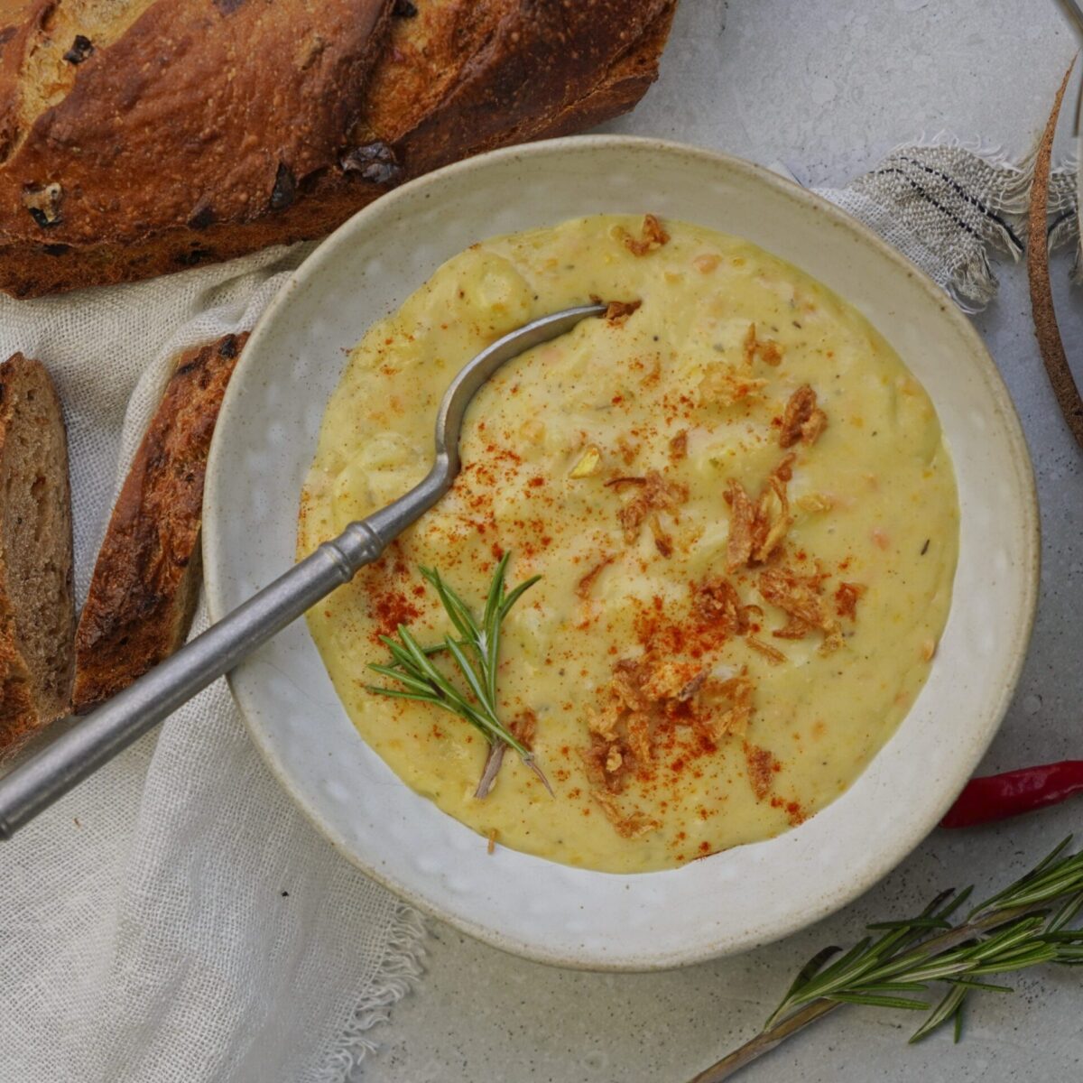 Extra creamy cheddar potato soup in a bowl with a spoon inside.