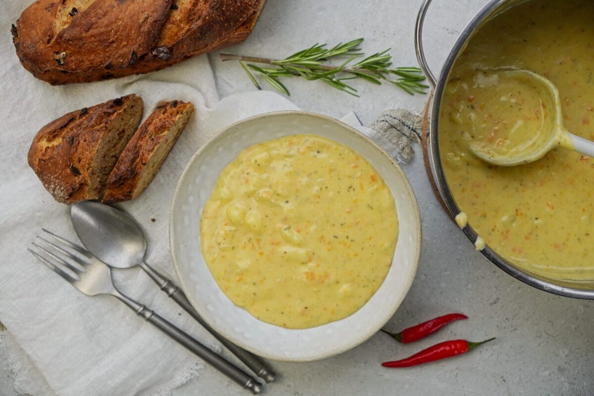 Extra creamy cheddar potato soup in a bowl with fresh bread on the side.