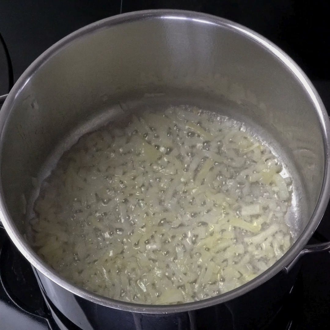 Translucent onions cooking in a pot.