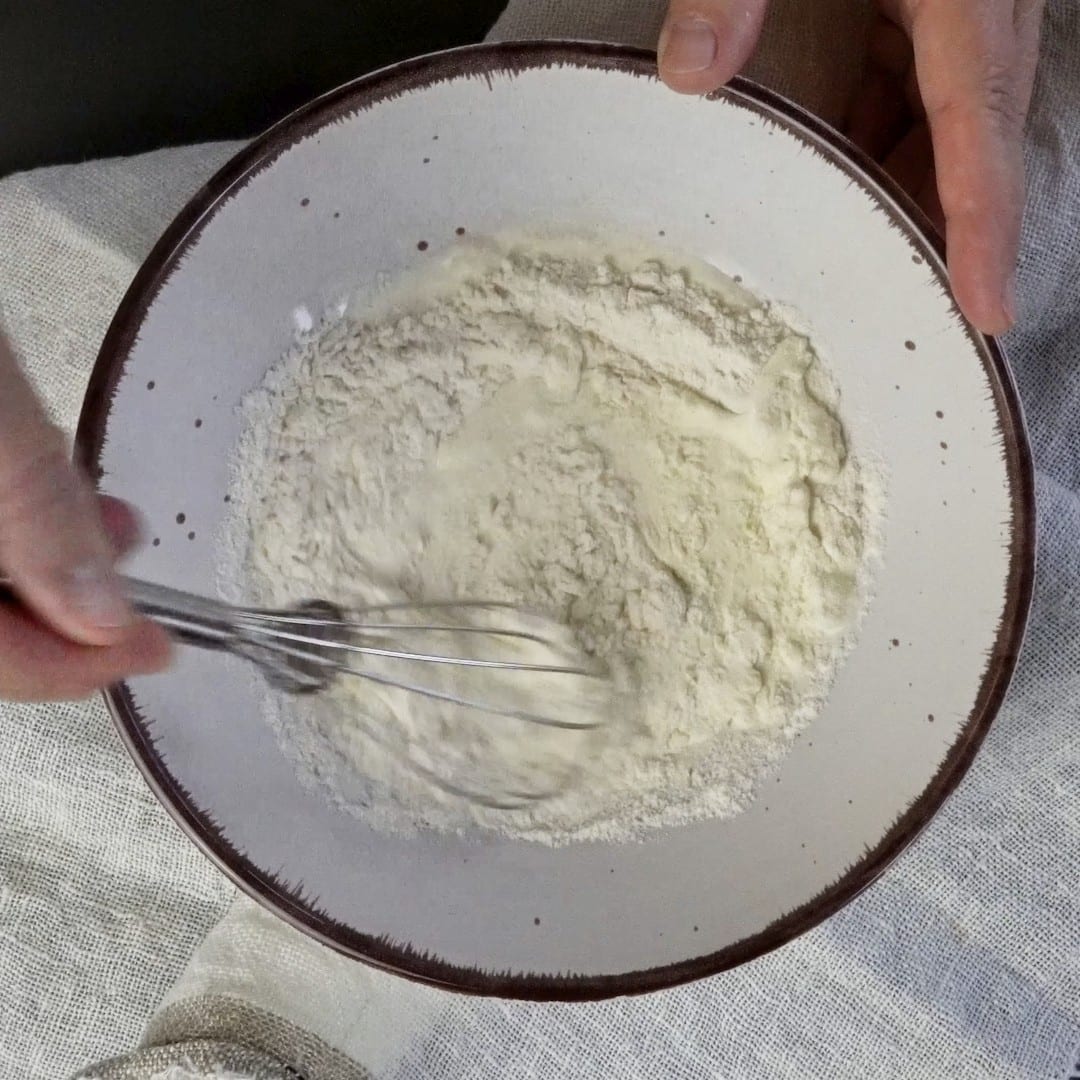 Mixing flour and heavy cream to make a smooth, creamy mixture.