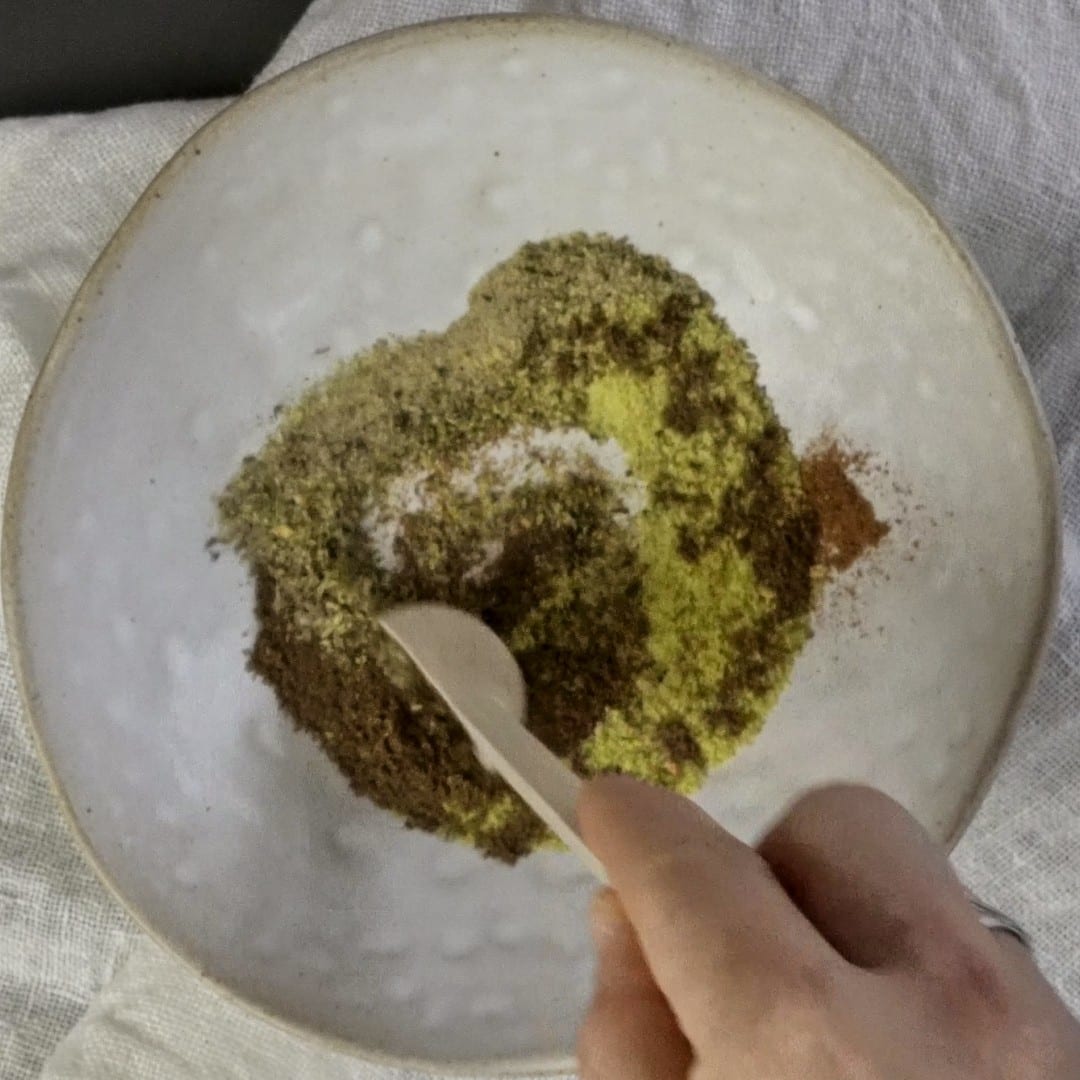 Mixing spices before adding them to cheesy potato soup.