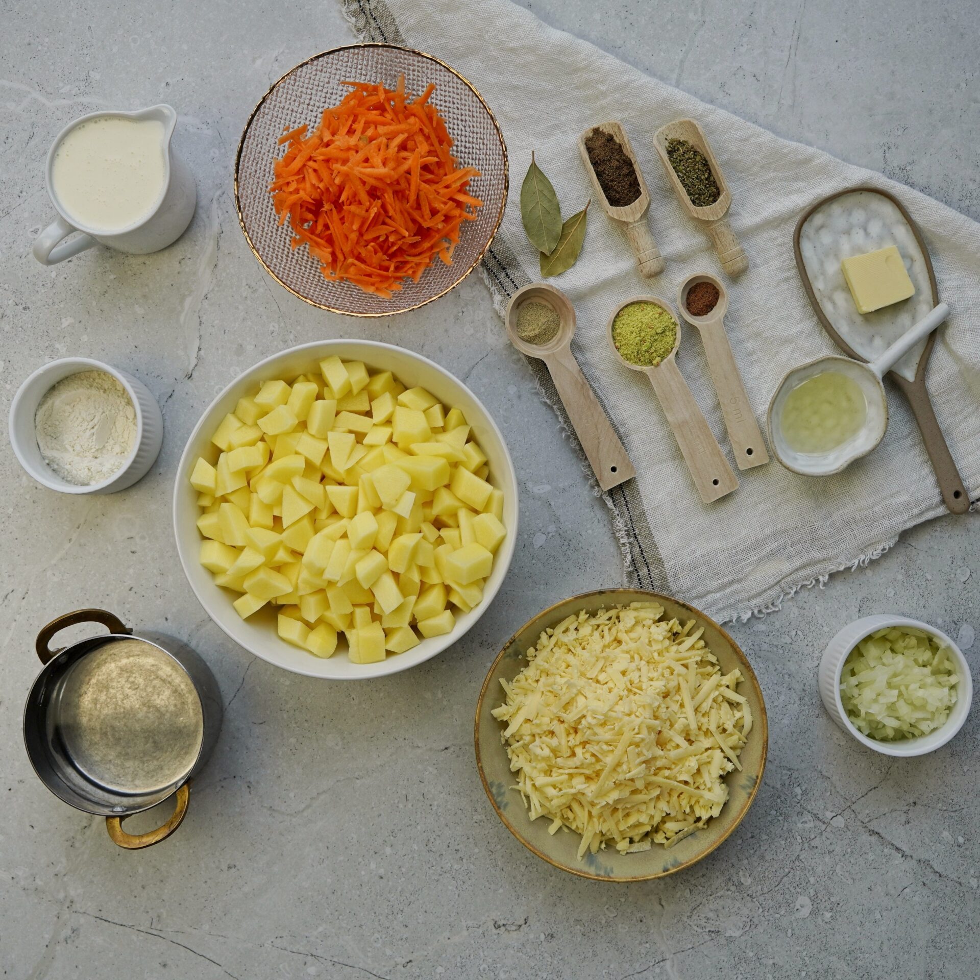 Shredded cheese and other chopped ingredients you need for cheddar potato soup.