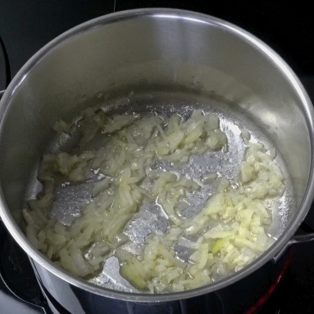 Frying onions in a pot with butter and oil.