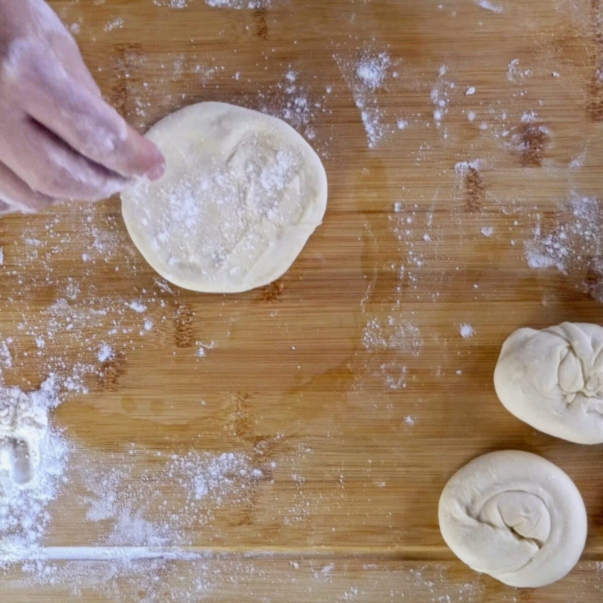 Preparing roti dough before cooking for a soft, flaky texture.