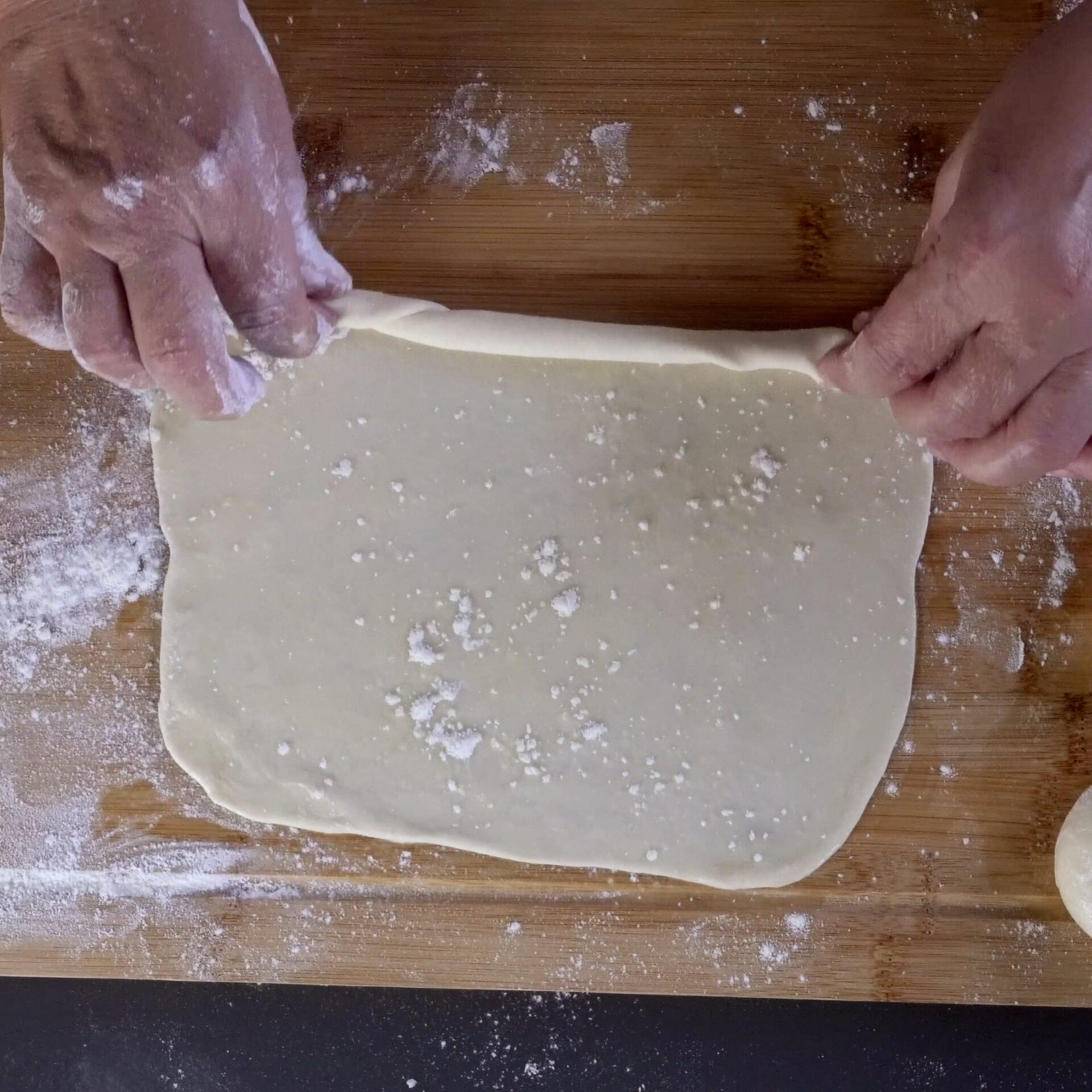 Rolling the dough into a log to create layers.