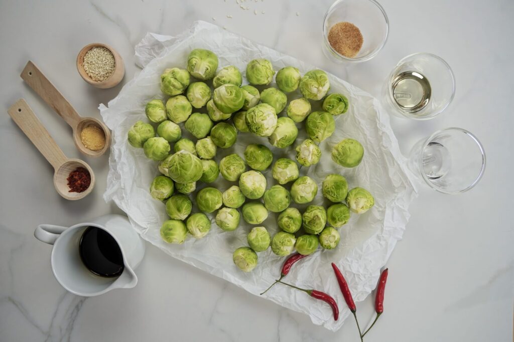 All ingredients for roasted Brussels sprouts. Brussels sprouts, soy sauce, rice vinegar, and spices.