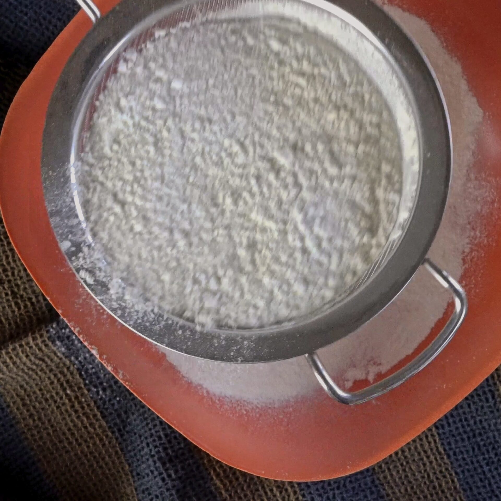 Sifting flour to remove lumps and aerate for soft roti dough.