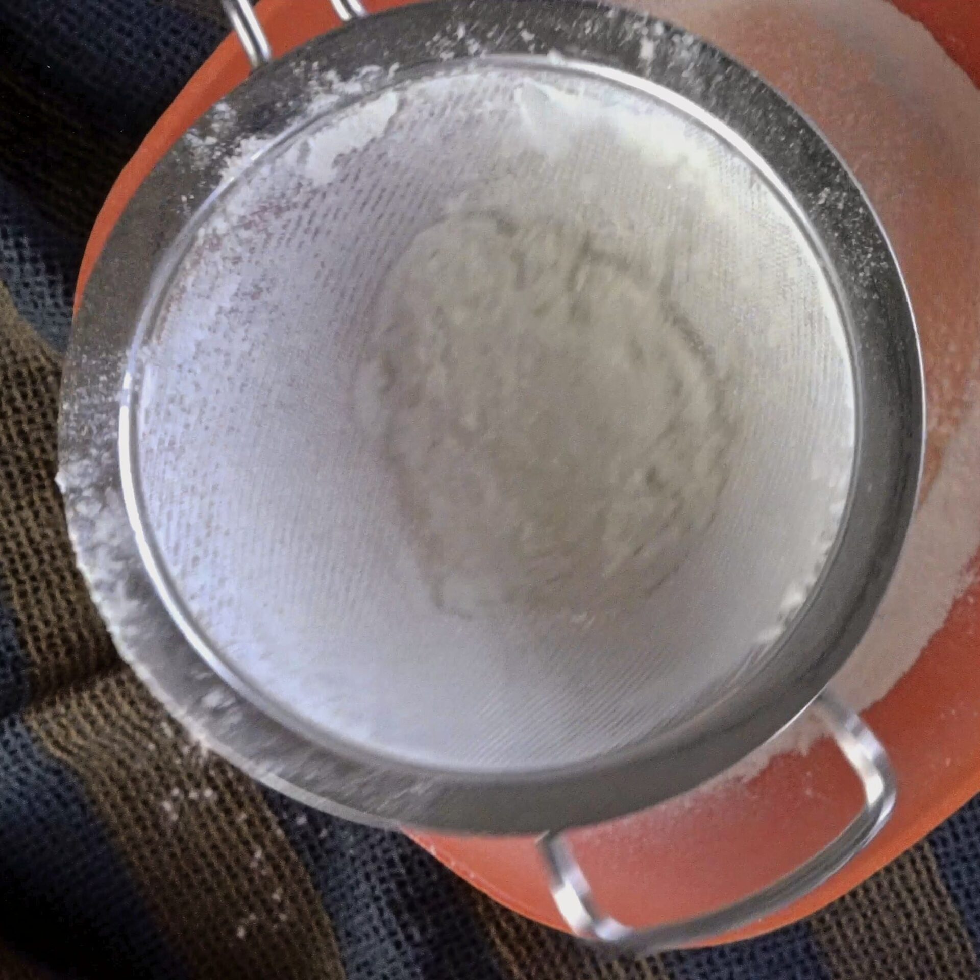Sifting flour to ensure a smooth and airy texture.