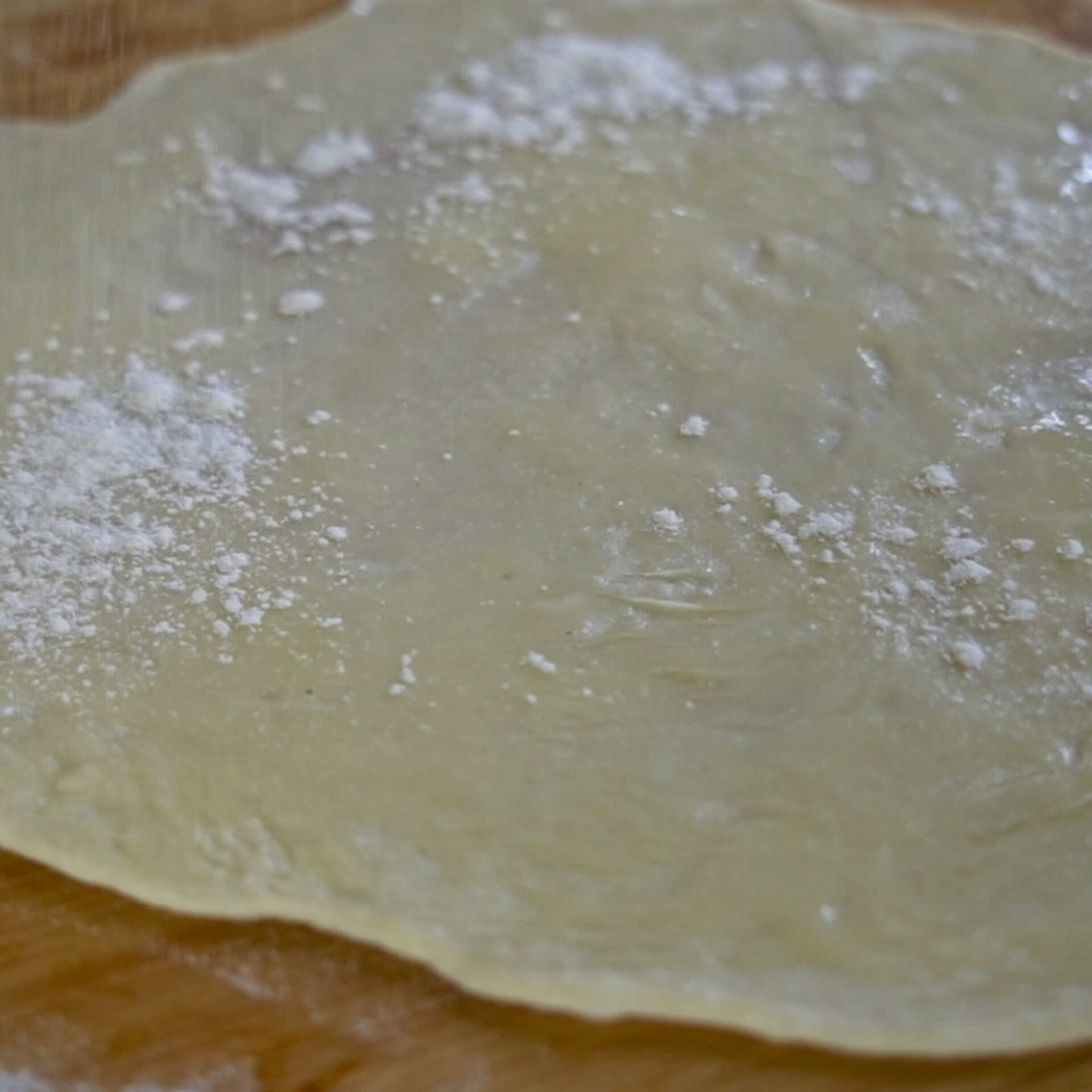 Sprinkling flour over the dough for a light, flaky texture.