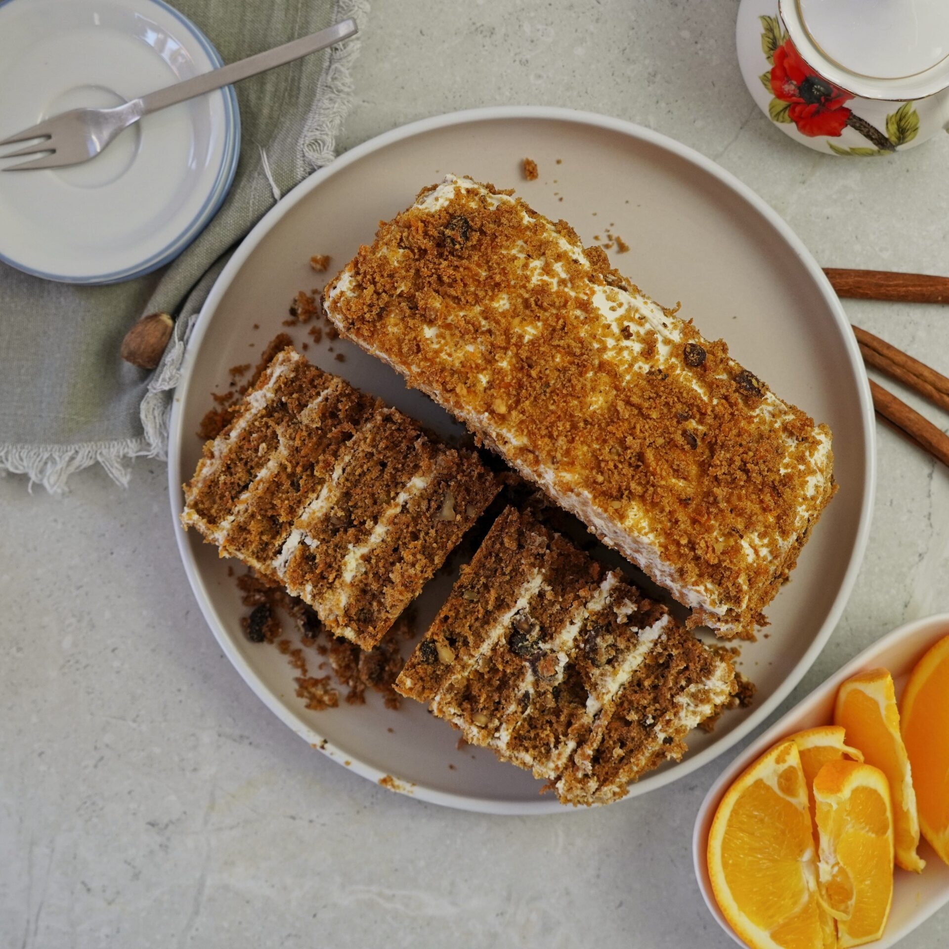 Carrot cake cut into three pieces, wrapped in plastic wrap, and ready to be stored in the fridge.