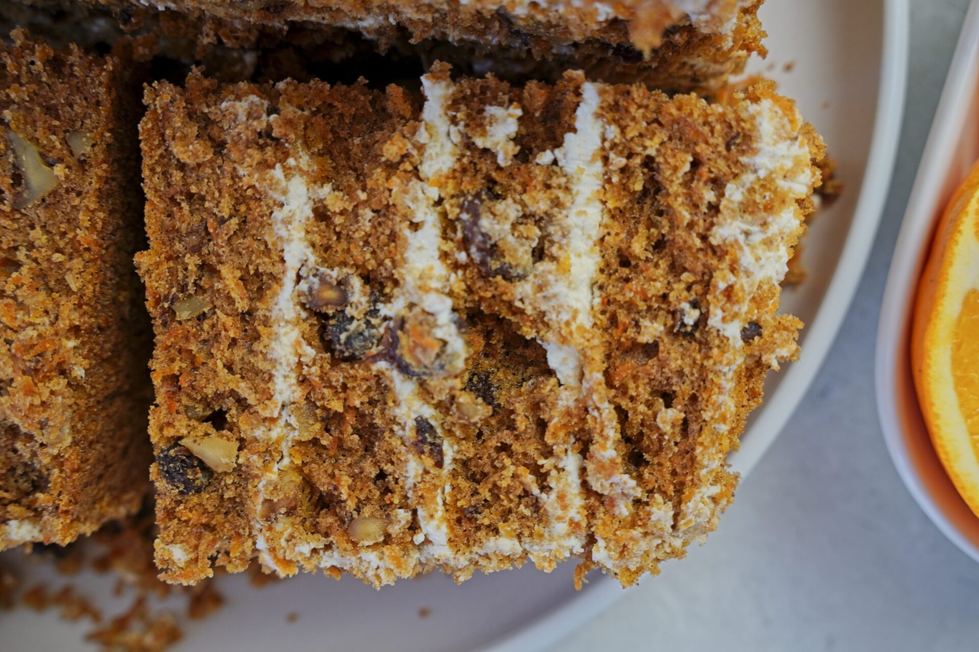 A piece of carrot cake with cream cheese frosting, ready to be stored.