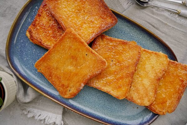 Arrangement of sugar toasts made with coconut oil, sugar, and toast bread on a blue plate.