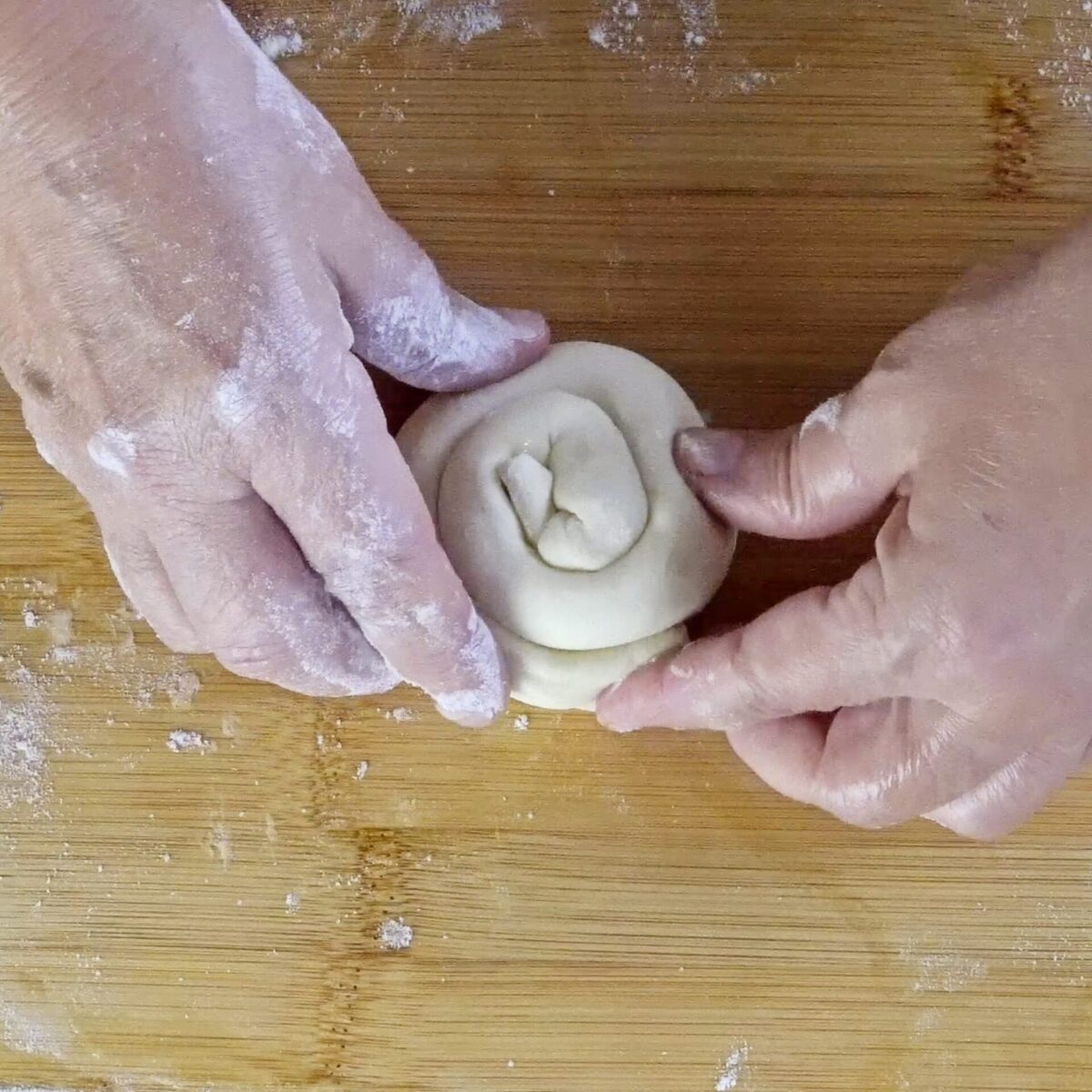 Twisting the dough into a snail shape to create layers.