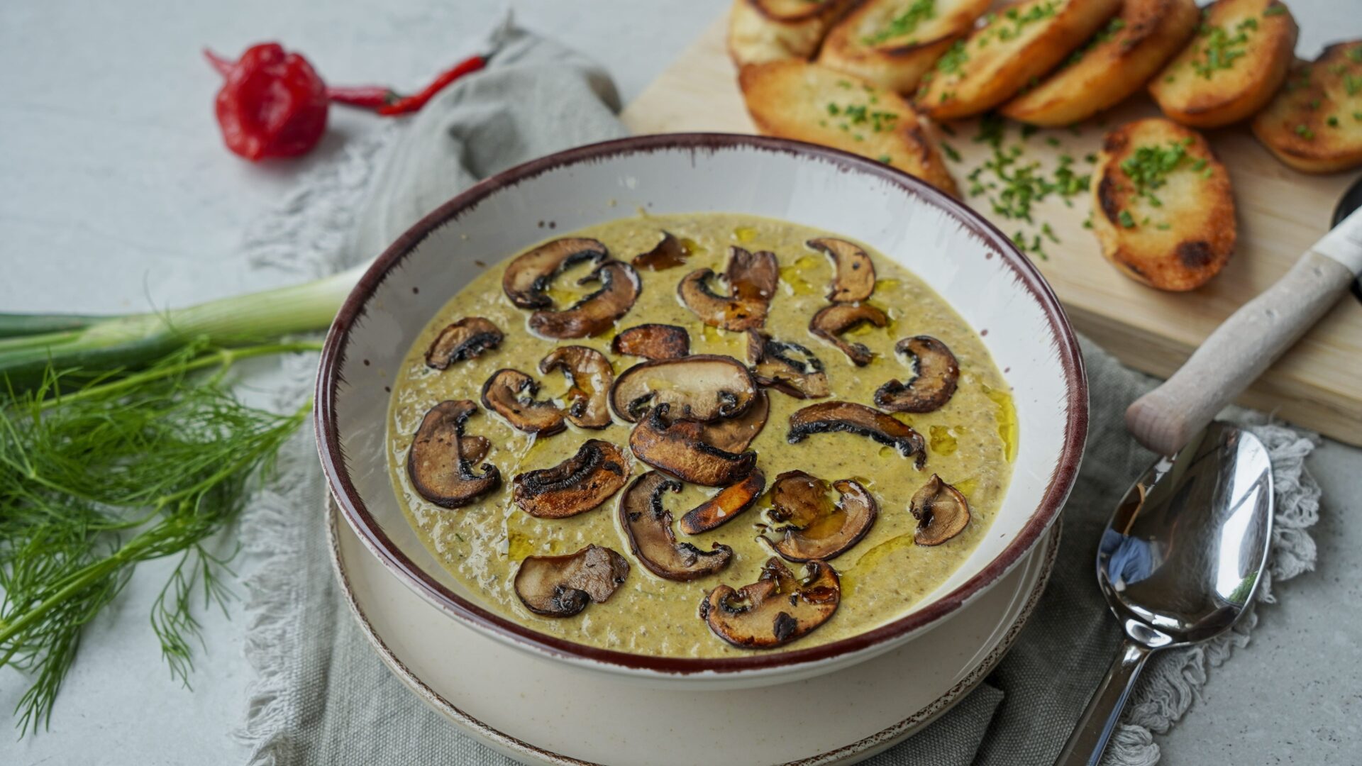 Close-up of mushroom soup with a creamy texture, topped with toasted mushrooms.