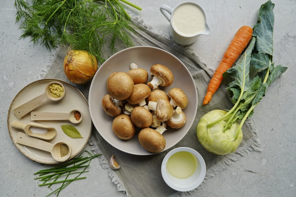 Ingredients for Ukrainian mushroom soup: mushrooms, kohlrabi, carrots, onions, heavy cream, and spices.