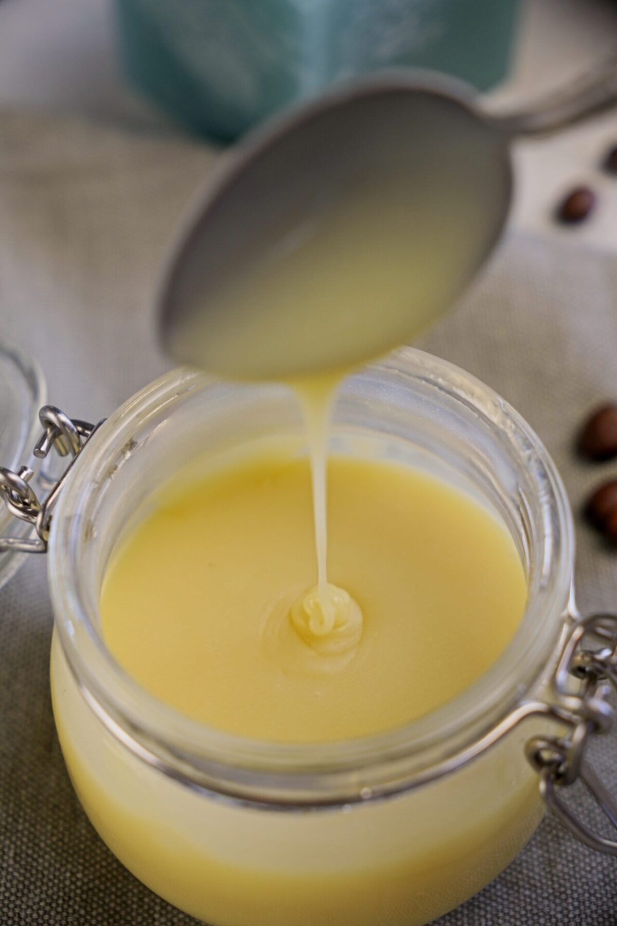 Taking a spoonful of white chocolate coffee syrup from a storage jar.